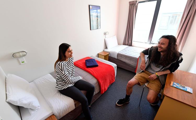 YHA Wellington youth travelers conversing in twin single beds