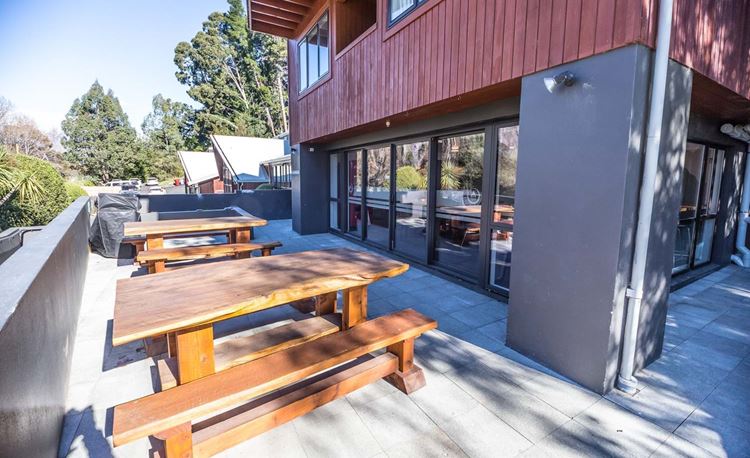 YHA Queenstown Lakefront outdoor deck area with picnic tables with lake views