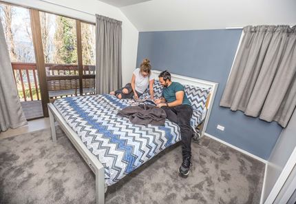 YHA Queenstown Lakefront youth travelers planning in double bedroom ensuite