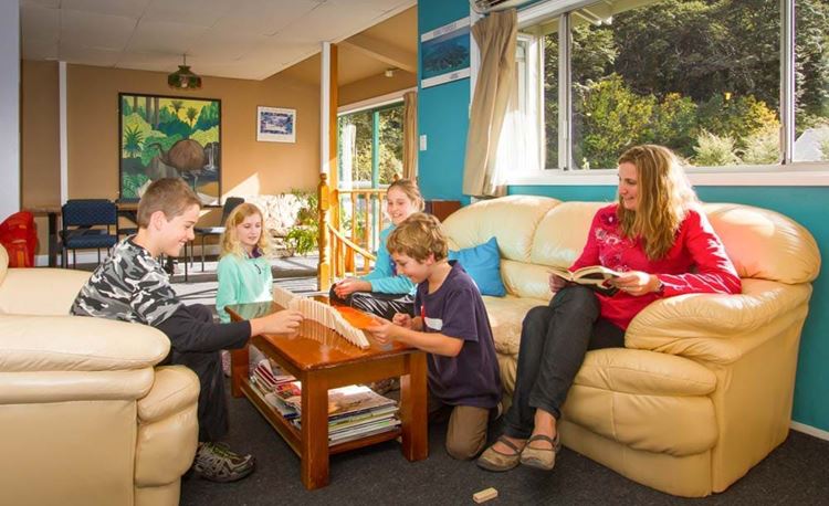 YHA Arthur's Pass family stacking dominoes in lounge area