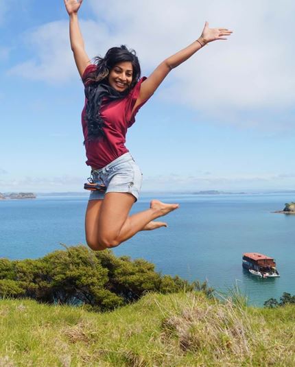 YHA Bay of Islands the Rock youth traveller jumping for joy in front of cruise 