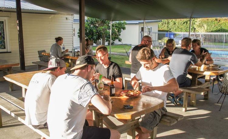 YHA Whangarei youth travelers enjoying a meal in outdoor picnic area
