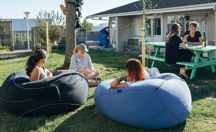 YHA Taupo youth travelers relaxing on beans bags in the courtyard