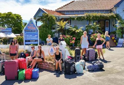 YHA Picton youth travelers with gear on hostel driveway