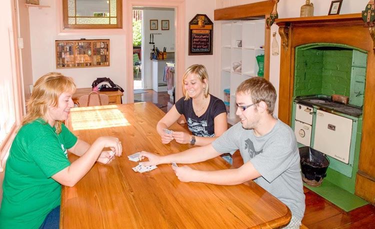 YHA Picton youth travelers playing cards in dining area