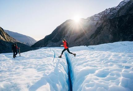 YHA Franz Josef traveller jumping over glacier creek