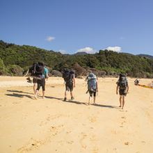 YHA Nelson travellers walking along a beach in the Abel Tasman