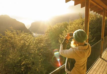 YHA Te Anau traveller taking photo of valley at sunset
