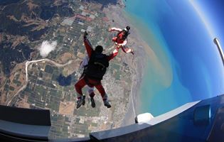 Tandem duo jumping out of plane over abel tasman