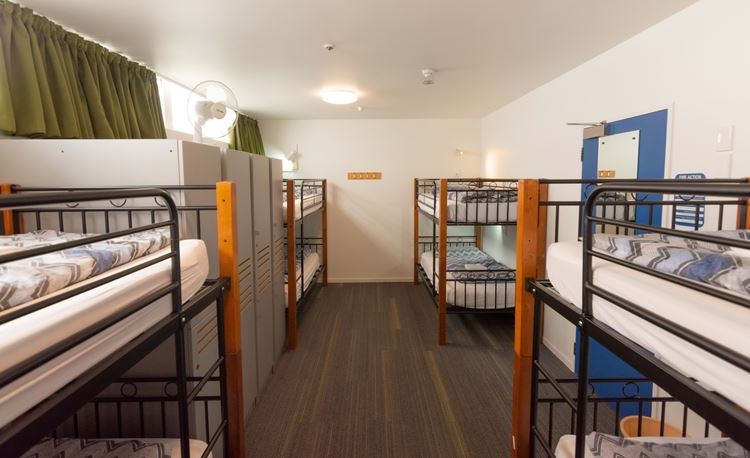 8 bed dorm room with lockers and reading lights at YHA Auckland International